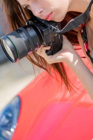 Moscow. Russia. August 13, 2021. Girl with a camera. Photoshoot with a red car.