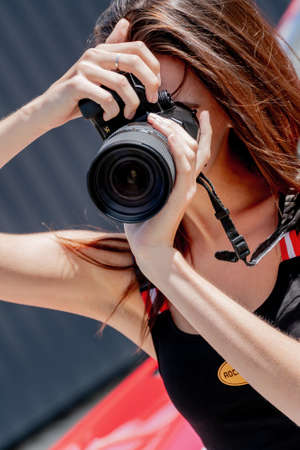 Moscow. Russia. August 13, 2021. Girl with a camera. Photoshoot with a red car.