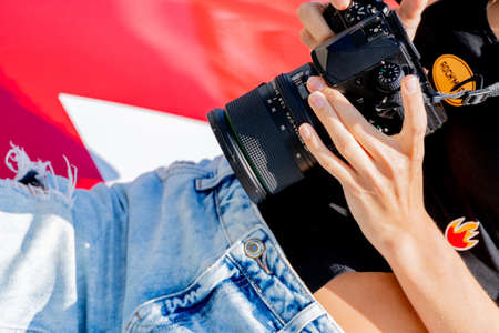 Moscow. Russia. August 13, 2021. Girl with a camera. Photoshoot with a red car.のeditorial素材