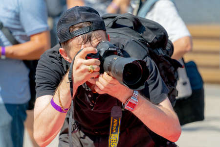 Moscow. Russia. August 14 2021. Photographer holds a camera with a large lens.のeditorial素材