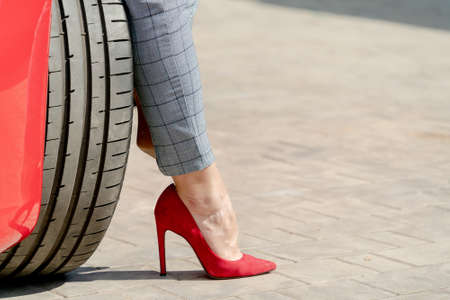 Girl in red shoes and a red car on a summer sunny day.の写真素材