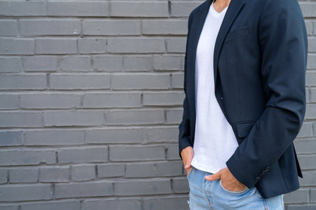 White guy in a white T-shirt and jacket. Male model against the background of the wall.の写真素材