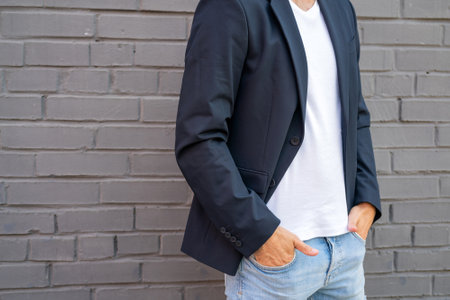 White guy in a white T-shirt and jacket. Male model against the background of the wall.の写真素材