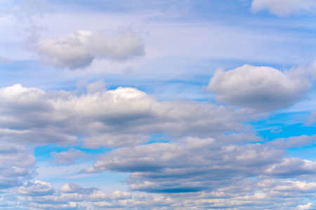 Beautiful white clouds on a bright blue background. Atmospheric weather phenomenon.の写真素材