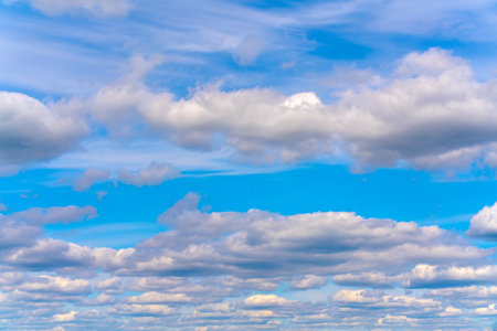 Beautiful white clouds on a bright blue background. Atmospheric weather phenomenon.の写真素材