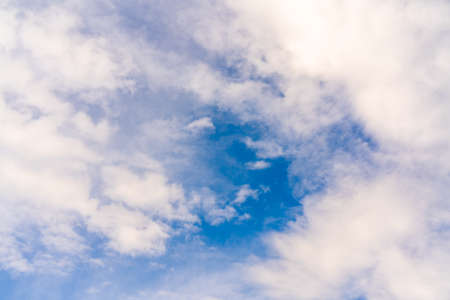Beautiful white clouds on a bright blue background. Atmospheric weather phenomenon.