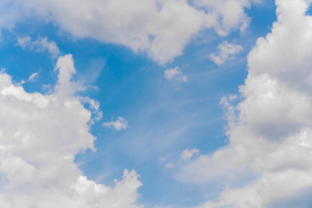 Beautiful white clouds on a bright blue background. Atmospheric weather phenomenon.の写真素材