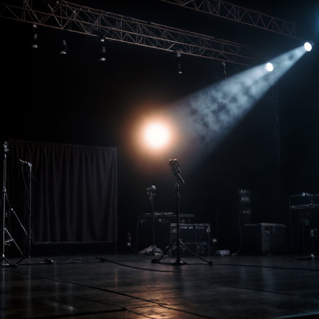 Microphones and amplification equipment on stage are illuminated by a spotlight.の素材