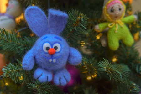 Blue hare Christmas toy hanging on the branches of a Christmas tree. Festive Christmas background.の写真素材