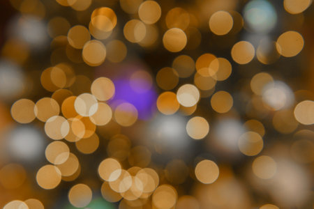 Chaotically placed bokeh circles shine with festive lights. Festive Christmas background.