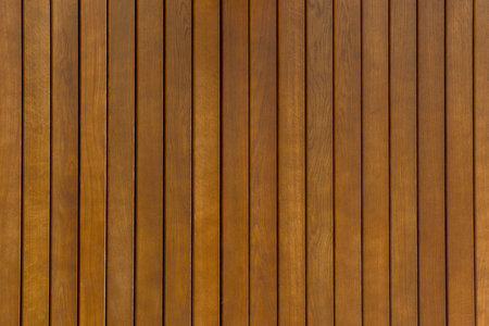 Fence of dark brown wooden planks with matte varnish coating. Wooden texture background.の写真素材
