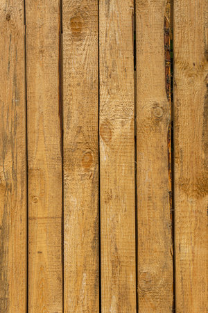 Rough-cut wooden boards. Barrier fence made of unplaned boards.の写真素材