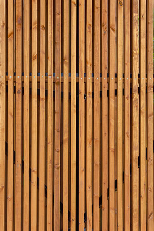 Fence made of wooden brown vertical slats. Abstract background.