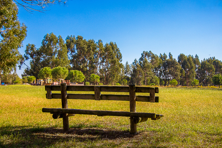 Wooden Bench in the Country, under a Beautiful Blue Skyの写真素材