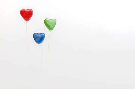 Colorful heart shaped balloons, floating on white background.の写真素材