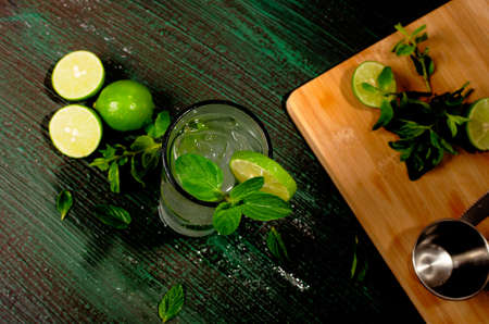 Mojito, cocktail of Cuban origin on a green table decorated with cocktail elements. Wooden background.の写真素材