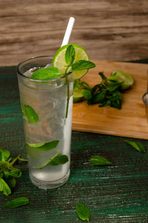 Mojito, cocktail of Cuban origin on a green table decorated with cocktail elements. Wooden background.の写真素材