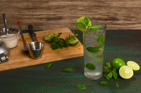 Mojito, cocktail of Cuban origin on a green table decorated with cocktail elements. Wooden background.の写真素材