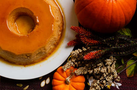 Pumpkin flan, dessert made for the Day of the Dead. Dessert on wooden table with autumn decoration around.の写真素材