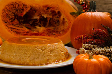 Pumpkin flan, dessert made for the Day of the Dead. Dessert on wooden table with autumn decoration around.の写真素材