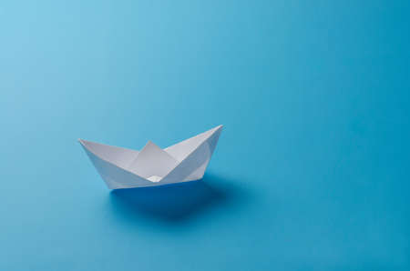 paper boat on blue background, cutout, isolated.の写真素材