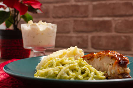 Roasted ribs marinated in barbecue sauce accompanied by mashed potatoes, spaghetti and bread. Plate of food served on wooden tableの写真素材