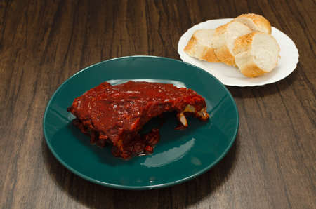 Roasted ribs marinated with barbecue sauce on wooden table.の写真素材