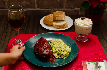 Roasted ribs marinated in barbecue sauce accompanied by mashed potatoes, spaghetti and bread. Plate of food served on wooden tableの写真素材