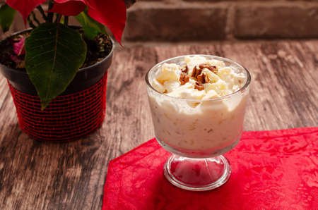 Apple salad with cream. Bowl with apple salad on wooden table with poinsettia.の写真素材