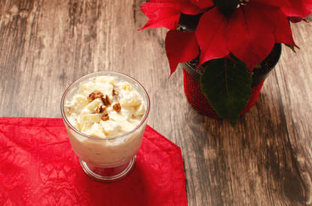 Apple salad with cream. Bowl with apple salad on wooden table with poinsettia.の写真素材