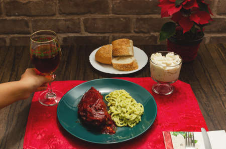 Roasted ribs marinated in barbecue sauce accompanied by mashed potatoes, spaghetti and bread. Plate of food served on wooden tableの写真素材