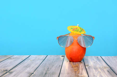 Mango with glasses on wooden table with blue background. Summer background.の写真素材