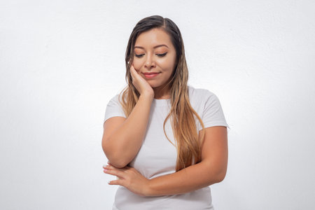 Portrait of thoughtful person. Portrait of Mexican woman isolated on white background in thoughtful...