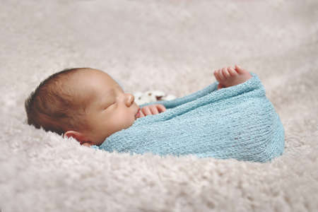 Portrait of a newborn baby wrapped in a plush blanket. Newborn portrait.の写真素材