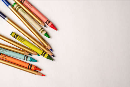 Colored pencils and crayons disordered on white background. Group of pencils and crayons of...