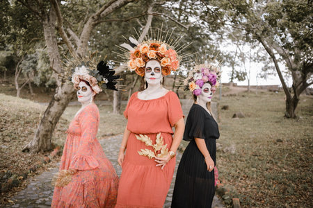 Group portrait of three women with the makeup of the catrinas.. Makeup for the celebration of Day of the Dead in Mexico. Outdoor portrait.の写真素材