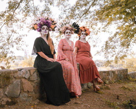 Group portrait of three women with the makeup of the catrinas.. Makeup for the celebration of Day of the Dead in Mexico. Outdoor portrait.の写真素材