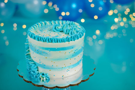 Blue and white birthday cake with balloons in the background. Photo set decoration for photo shoot.の写真素材