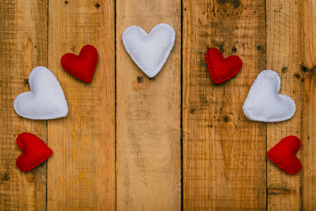 Group of hearts made of felt on wooden table forming an arch. Valentine's day background.の写真素材