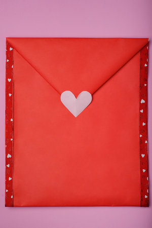 Paper envelope decorated with hearts on a pink background.