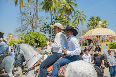 Villa de Alvarez, Colima, Mexico. February 11, 2023. Group of people on horseback in the horse parade for the charro bullfighting festivities in the city of Villa de Alvarez.のeditorial素材
