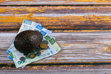 Avocado and Mexican banknotes on wooden table. Concept of rising cost of avocado production and consumption.の写真素材