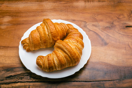 Croissants in white plate on wooden table. top view.の写真素材