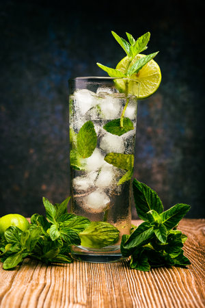 Mojito, cocktail decorated with lemon and peppermint on a wooden table. No straw.の写真素材