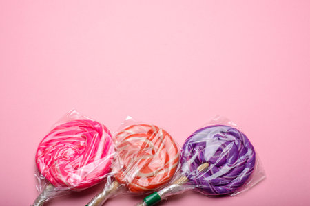 Lollipops wrapped on a pink background. Copyspace.