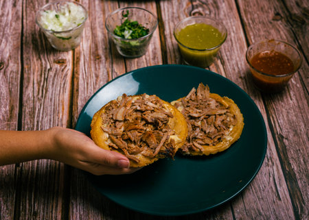 Sope pocho, typical Mexican food served with condiments on a wooden table.の写真素材