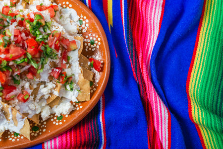 Nachos with cream cheese and pico de gallo on a colorful serape.の写真素材