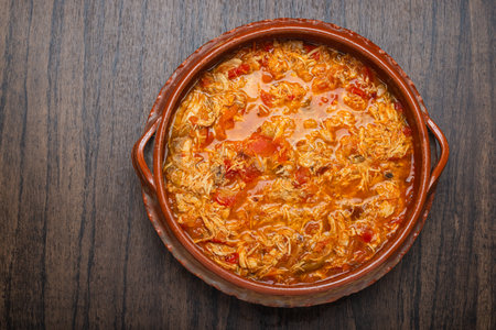 Authentic mexican chicken tinga, typical mexican food prepared in a clay pot on a wooden table.の写真素材