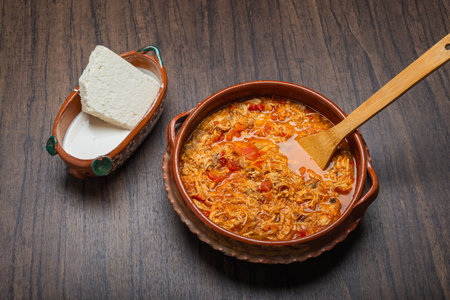 Authentic mexican chicken tinga, typical mexican food prepared in a clay pot on a wooden table.の写真素材