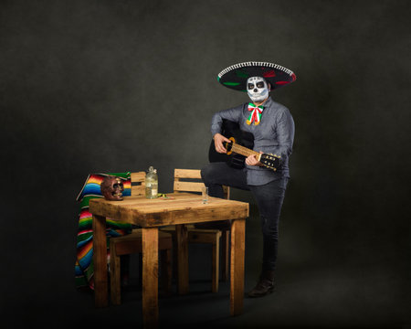 Catrin wearing mariachi hat and playing guitar in a bar. Day of the dead celebration.の写真素材